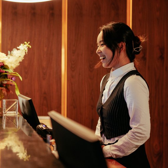 Individual at reception desk looking at computer screen