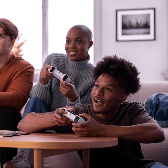 Three individuals engaged in playing video games
